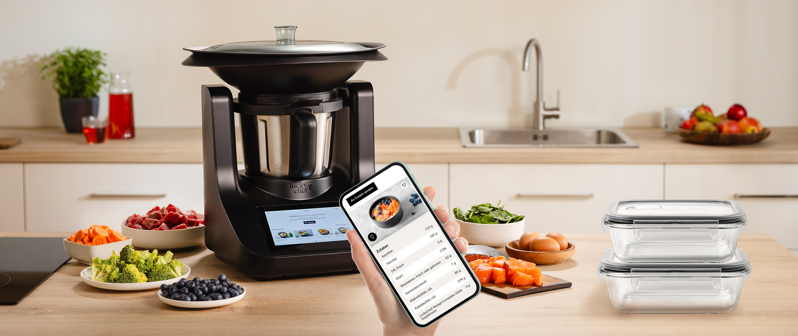 Einkaufsliste auf dem Smartphone neben CookA Küchenmaschine, frischen Zutaten und Vorratsbehältern für selbstgekochtes Hundefutter